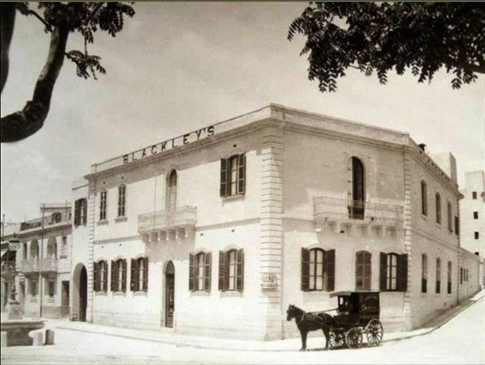 Historic photograph of the Blackley’s building in Pietà, Malta, with a horse-drawn carriage outside